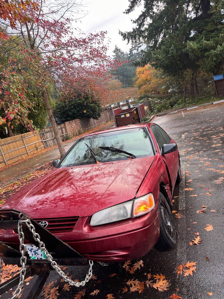 Red Toyota Camry chained up and ready to tow